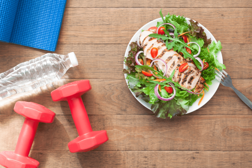 Photo of a salad, weights and water to show healthy snacks