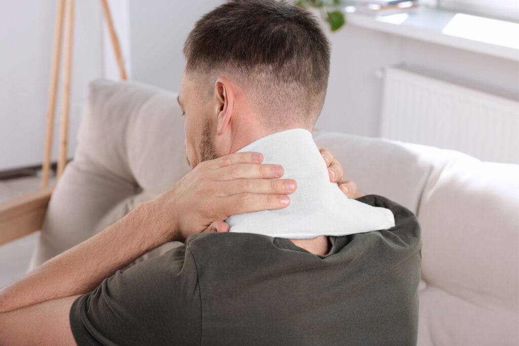 picture of man applying heat pack to his neck